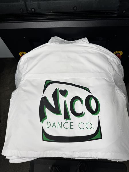 Green and black dance studio logo printed large on the back of a white jacket