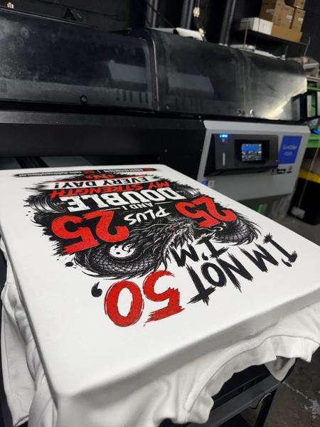 Full-color red and black dragon birthday design on a white tee, fresh off the DTG printer