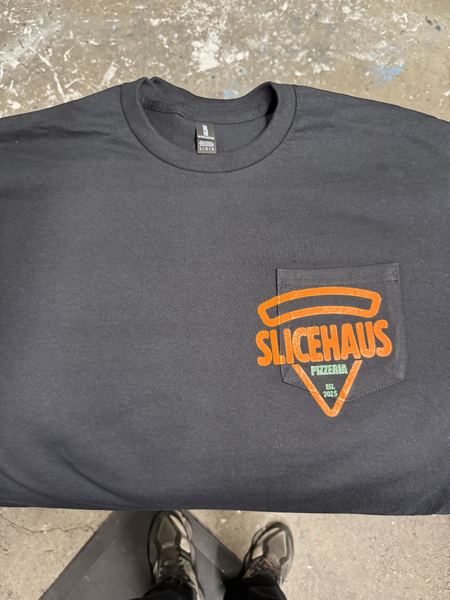 Orange and green pizzeria logo printed over the pocket of a black pocket tee